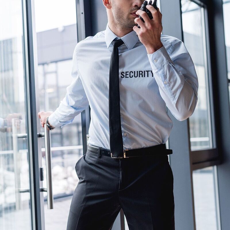 Security Guard spricht in Walkie Talkie und schließt eine Tür